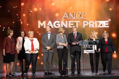 ANCC Magnet Recognition Program Leadership on stage with Magnet Prize recipient